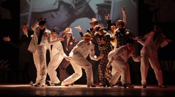 Bailarinas vestidas a caráter no palco durante apresentação de malandragem #pracegover 