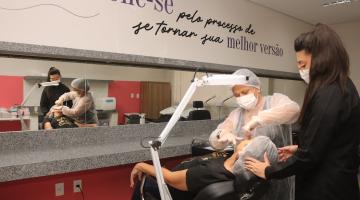 professora mostra como aluna depila pessoa em cadeira #paratodosverem