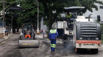 Homens e máquinas está fazendo pavimentação de rua. #Pracegover