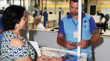 mulher está no ponto onde agente orienta sobre a zona zul #pracegover 