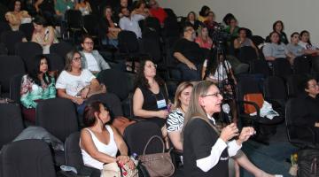 palestrante fala com mulheres sentadas assistindo #pracegover 