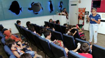 crianças assistem a palestra no auditório #pracegover 