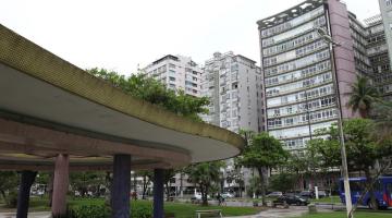 pérgola no jardim da orla, com edifício verde mar ao fundo. #paratodosverem