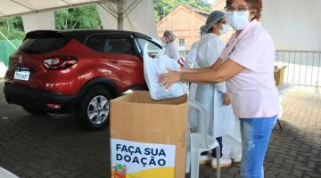 mulher coloca doação em caixa #paratodosverem 