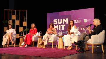 cinco mulheres sentadas em um palco. Uma delas fala ao microfone. #paratodosvere