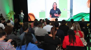 painel com pessoa do salão autoestima exibido em auditório. #paratodosverem