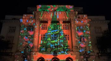fachada da prefeitura com projeção de pinheiro de natal à noite. #paratodosverem 
