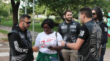mulher distribui panfletos na rua #paratodosverem