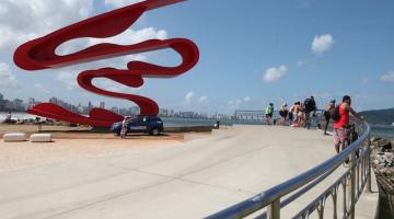 monumento no Novo Quebra-Mar e pessoas em torno observando a paisagem. #paratodosverem