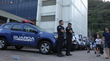 guardas municipais estão na porta de escola com alunos chegando. #paratodosverem