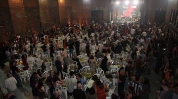 festa com centenas de pessoas em pé e sentadas. #paratodosverem