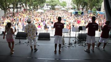 músicos de costa para a foto em palco na praça mauá, com grande público ao fundo. #paratodosverem