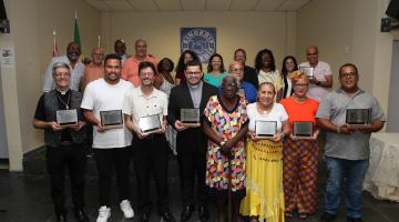 premiados posam para foto segurando placas. #paratodosverem 