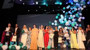 educadores premiados estão no palco. alguns aplaudem. Há balões de gás subindo. #paratodosverem 
