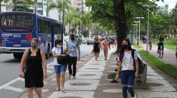 Pessoas andam no calçadão da orla usando máscara. #paratodosverem