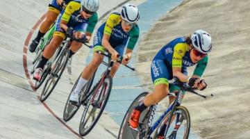 Atletas em cima da bicicleta pedalando em pista #paratodosverem