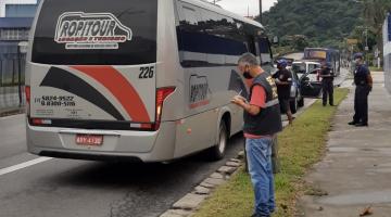 Micro-ônibus está parado em via. Ao lado há guardas municipais. #Paratodosverem