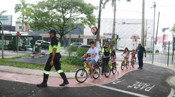 crianças de bicicleta seguem agente #paratodosverem