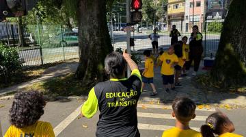 agente orienta crianças a atravessar a rua #paratodosverem 