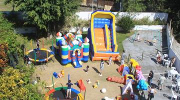 Playgrond com vários brinquedos e crianças brincando. #paratodosverem