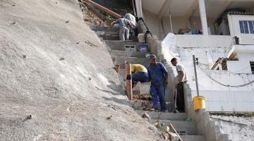 trabalhadores ao lado de parte concretada do morro #paratodosverem