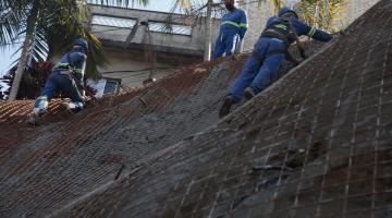 Homens estão trabalhando em encosta de morro. #Paratodosverem