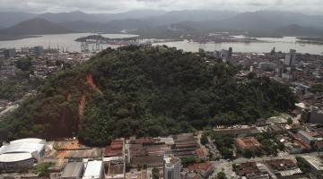 Vista geral de morros em Santos, com o mar ao fundo e a cidade em torno. #paratodosverem