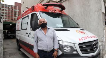 Homem está em pé diante de ambulância do samu. #paratodosverem