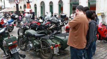 motos paradas em praça e várias pessoas olhando. #paratodosverem