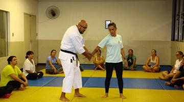 Professor ensina técnica para mulher com outros mulheres assistindo #paratodosverem