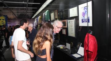 pessoas olhando exposição no museu pelé #paratodosverem 