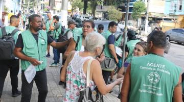 pessoas em contato com agentes na rua #paratodosverem
