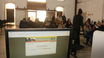 computador na frente de pessoas esperando atendimento #paratodosverem 
