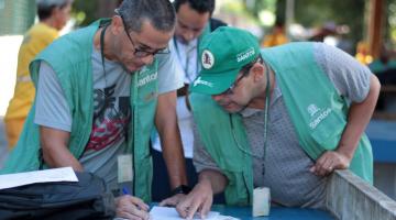 agentes olham papel em mesa #paratodosverem