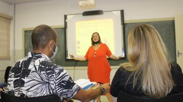 palestrante fala em frente a sala com duas pessoas assistindo #paratodosverem