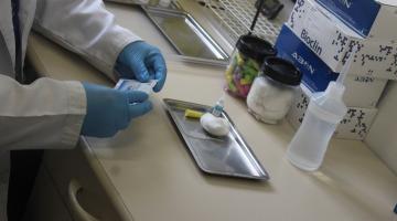 mãos com luvas mexem em medicamentos. #paratodosverem