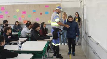 na sala de aula, agente segura aluno em demonstração #paratodosverem