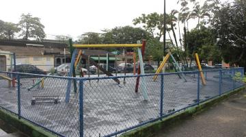 play ground com cerca e vegetação ao fundo. #paratodosverem