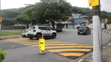 lombada em avenida com canteiro central ao lado esquerdo e poste ao direito. 