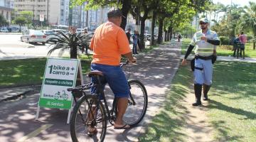 ciclista para na ciclovia ao lado de placa com agente da cet mais a frente #paratodosverem