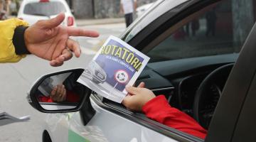 pessoa dentro do carro segura panfleto #paratodosverem