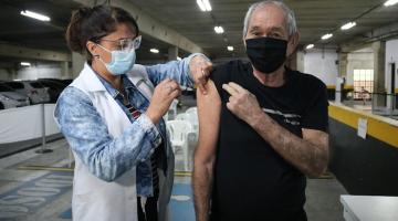 Mulher aplica vacina no braço de homem #paratodosverem
