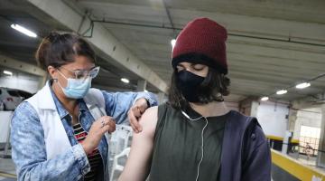 Jovem de toca recebe vacina no braço #paratodosverem