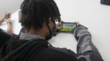 estudante jogando game no celular #paratodosverem