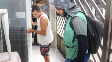 agente olha para geladeira que está sendo arrastada pelo dono. #paratodosverem
