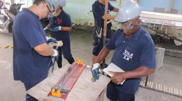 homes estão mexendo em máquina de corte de azulejo. #paratodosverem 