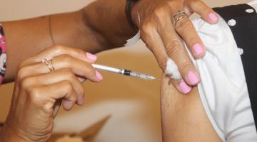 mãos de mulher vacinam um braço. #paratodosverem
