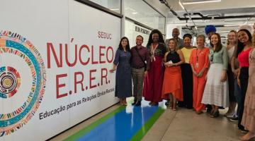pessoas posam na frente da entrada do núcleo #paratodosverem