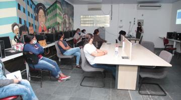 Várias pessoas sentadas em sala de aula assistindo palestra. #paratodosverem