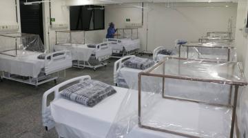 Vários leitos em uma sala com estruturas protetoras para os pacientes. #Paratodosverem